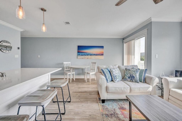 living room featuring crown molding and light hardwood / wood-style floors