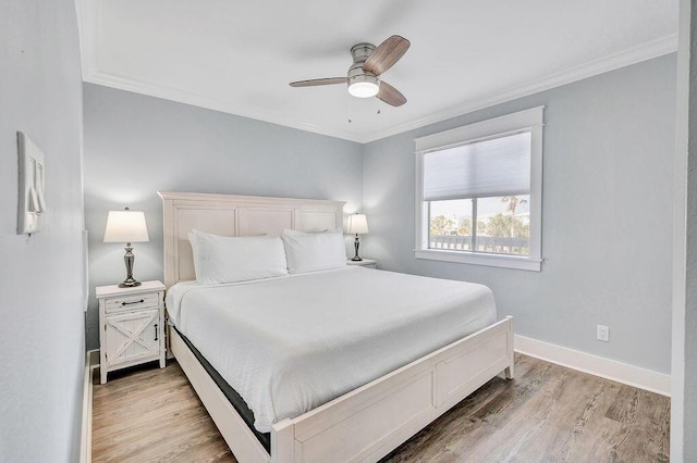 bedroom featuring ceiling fan, light wood-type flooring, and ornamental molding