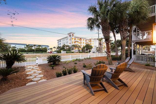 deck at dusk with a fenced backyard