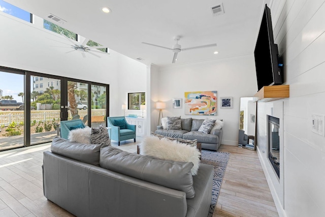 living area with visible vents, a ceiling fan, and a tile fireplace