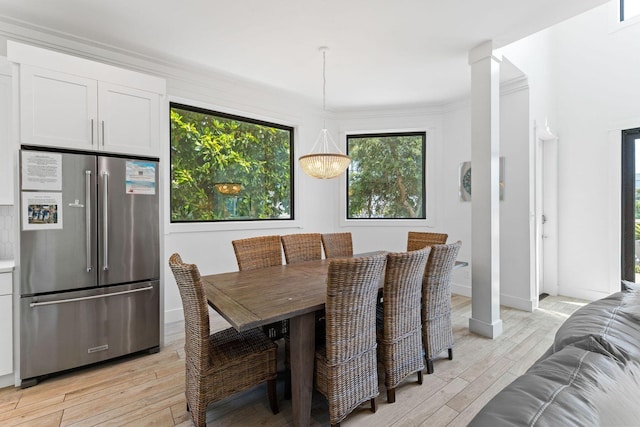 dining room with light wood-style floors, a chandelier, and baseboards