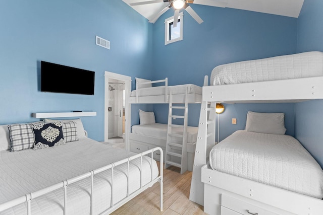 bedroom featuring a ceiling fan, visible vents, high vaulted ceiling, and wood finished floors