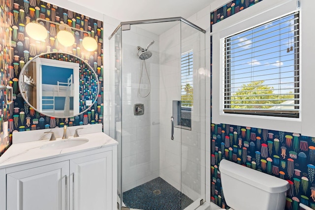 full bath with toilet, a stall shower, wallpapered walls, and vanity