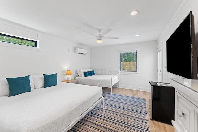 bedroom featuring light wood-style floors, recessed lighting, a ceiling fan, and a wall mounted AC