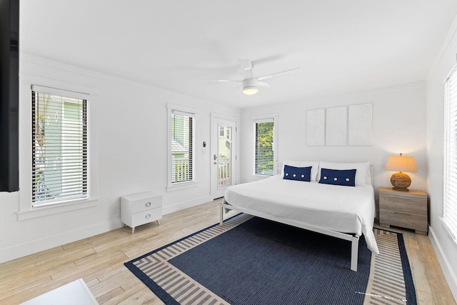 bedroom with access to exterior, a ceiling fan, baseboards, and wood finished floors