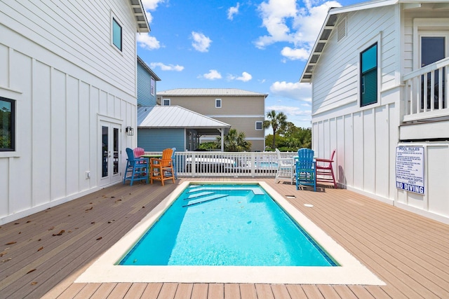 community pool with french doors and a deck