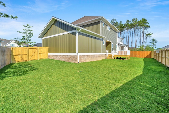 back of property with a wooden deck and a yard