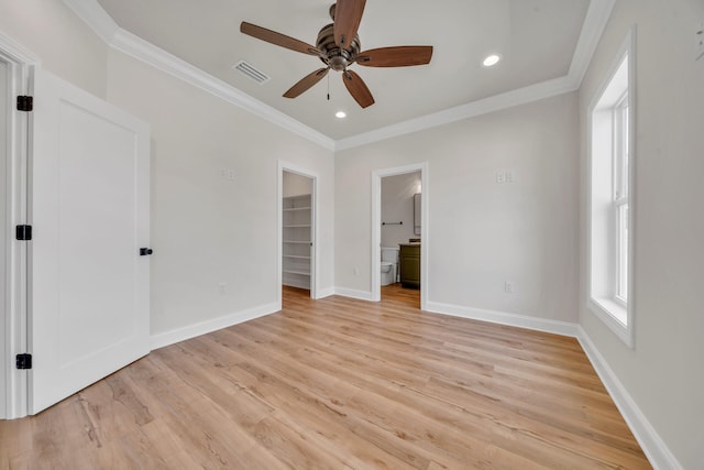 unfurnished bedroom featuring a walk in closet, ensuite bath, ceiling fan, crown molding, and light hardwood / wood-style floors