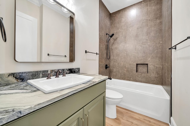 full bathroom with hardwood / wood-style floors, vanity, toilet, and tiled shower / bath