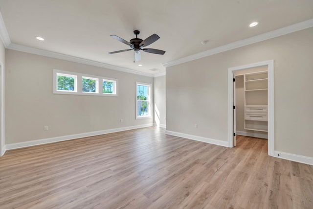 unfurnished bedroom featuring a walk in closet, ceiling fan, crown molding, light hardwood / wood-style flooring, and a closet