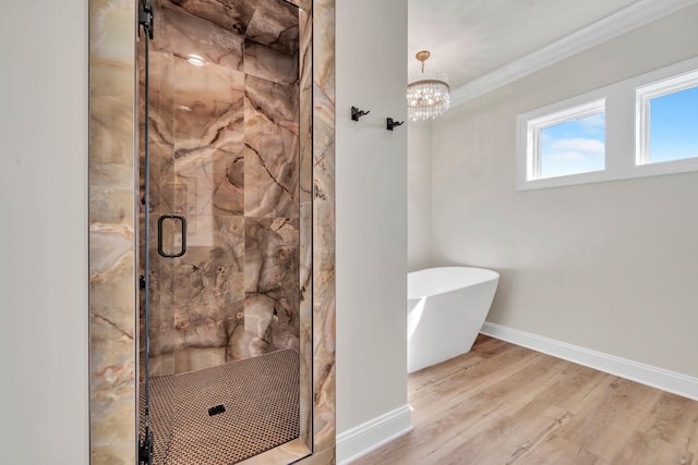 bathroom with wood-type flooring, crown molding, plus walk in shower, and an inviting chandelier