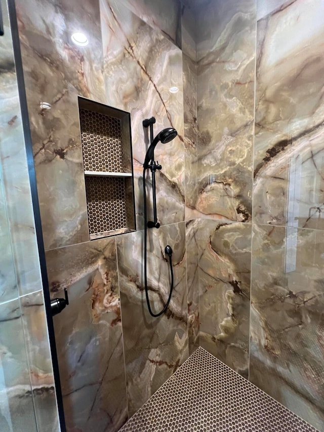 interior details featuring a tile shower