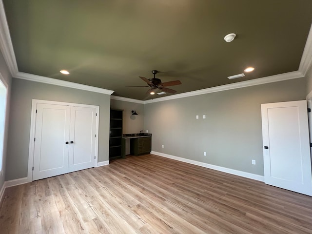 unfurnished bedroom featuring ceiling fan, crown molding, and light hardwood / wood-style flooring