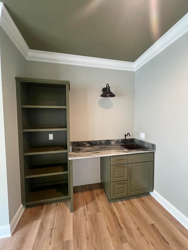 bar featuring crown molding, sink, and light hardwood / wood-style flooring