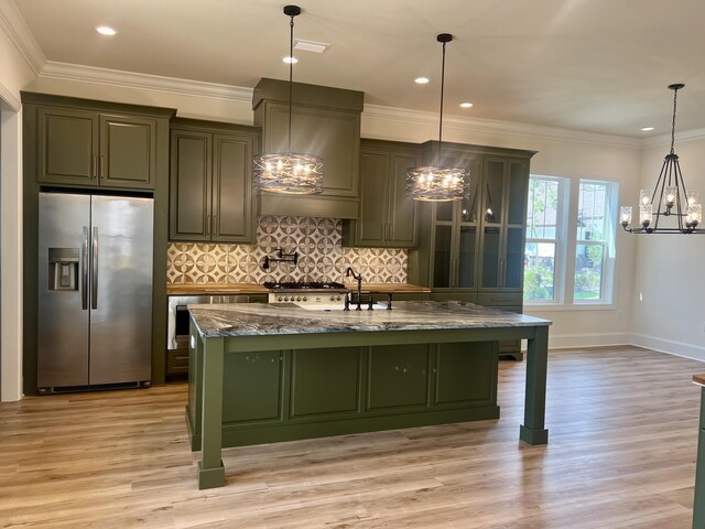 kitchen with stainless steel fridge with ice dispenser, light hardwood / wood-style flooring, dark stone countertops, a center island with sink, and custom range hood