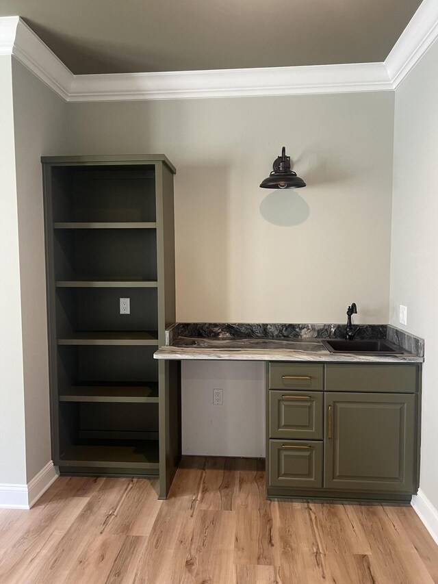 bar featuring crown molding, sink, and light hardwood / wood-style flooring