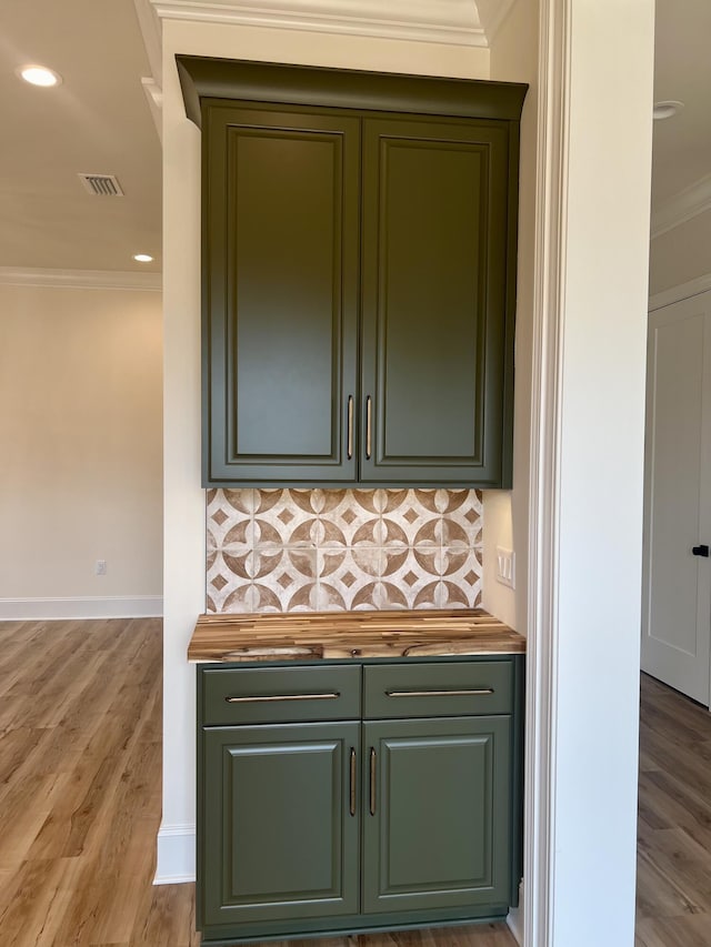 bar with ornamental molding, light hardwood / wood-style flooring, and tasteful backsplash