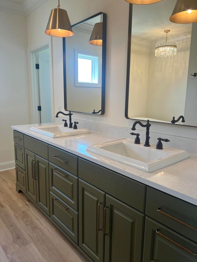 bathroom featuring an inviting chandelier, vanity, ornamental molding, and hardwood / wood-style flooring