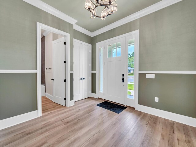 entryway featuring a chandelier, ornamental molding, and light hardwood / wood-style flooring