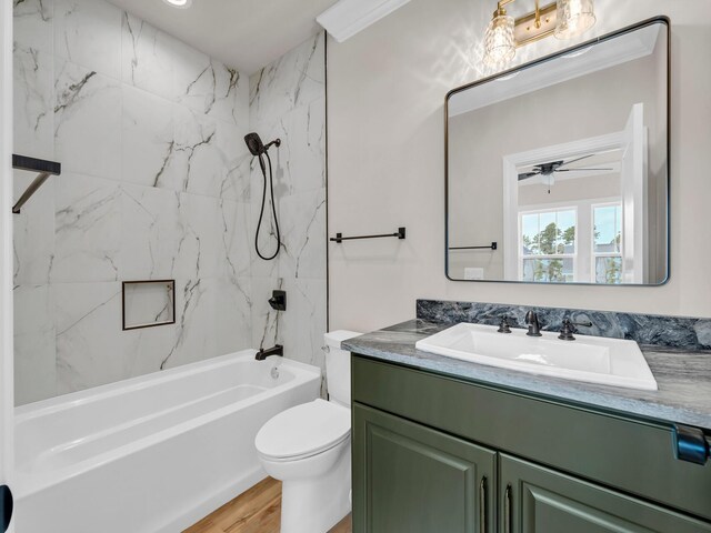 full bathroom featuring ceiling fan, tiled shower / bath combo, hardwood / wood-style floors, toilet, and vanity