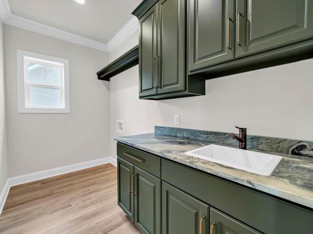 kitchen featuring green cabinets, crown molding, sink, and light hardwood / wood-style flooring