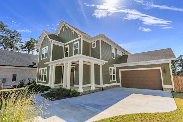 view of front of property with concrete driveway, board and batten siding, an attached garage, and roof with shingles