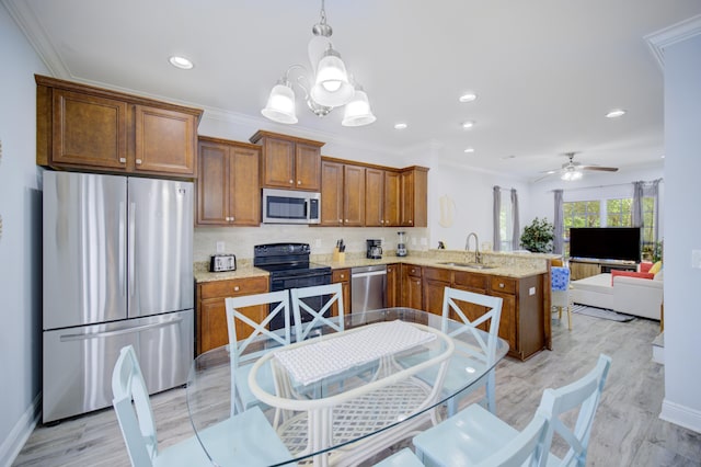 kitchen featuring ceiling fan with notable chandelier, backsplash, kitchen peninsula, appliances with stainless steel finishes, and sink