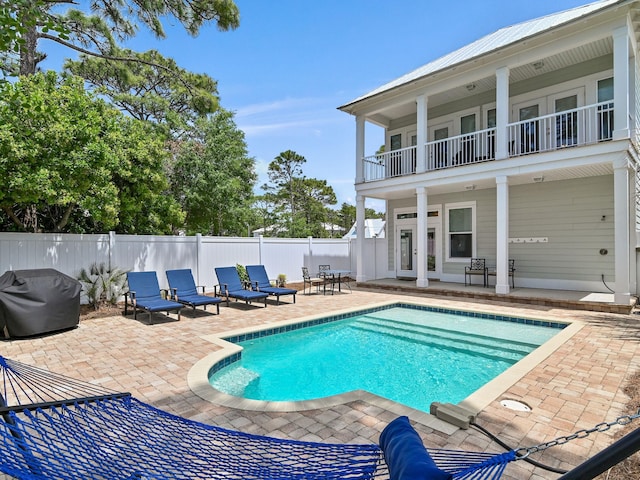 view of swimming pool featuring a patio area, french doors, and area for grilling