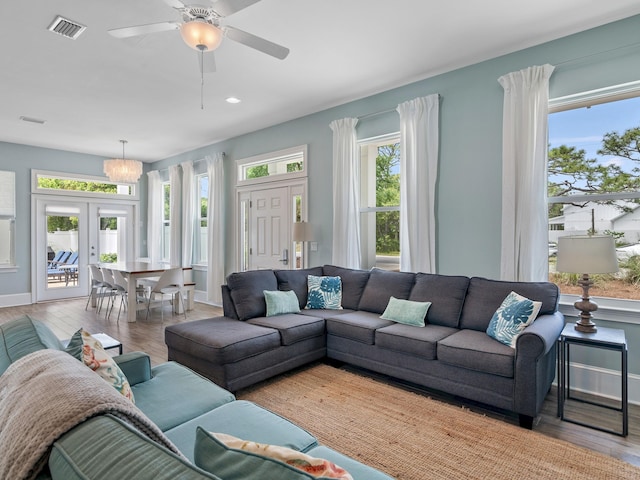 living room with a healthy amount of sunlight, french doors, ceiling fan, and hardwood / wood-style flooring