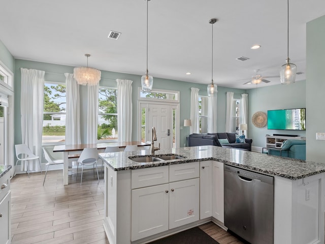 kitchen with stone counters, white cabinetry, sink, pendant lighting, and stainless steel dishwasher