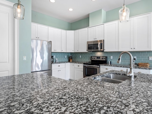 kitchen featuring tasteful backsplash, appliances with stainless steel finishes, and white cabinetry