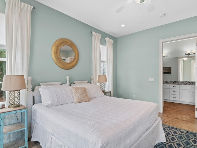 bedroom with ceiling fan, ensuite bathroom, and dark wood-type flooring