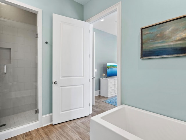 bathroom with wood-type flooring and independent shower and bath