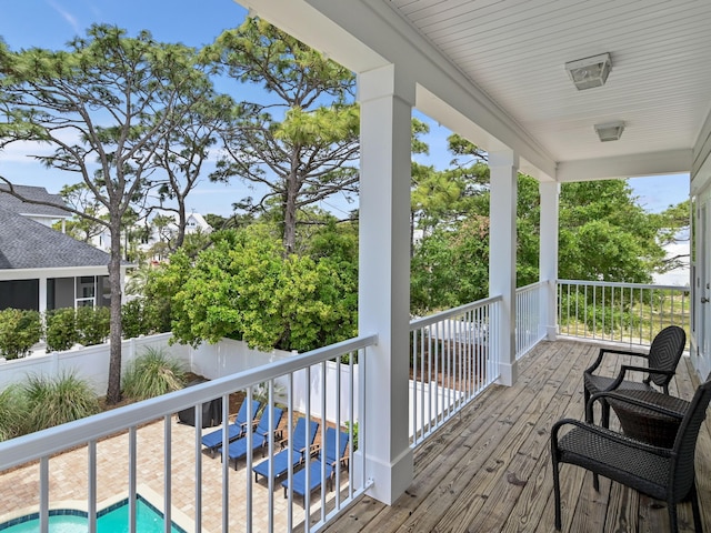 wooden deck with a fenced in pool