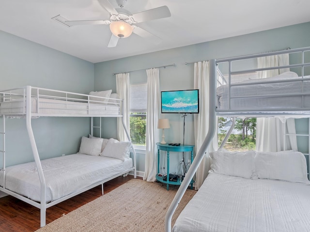 bedroom featuring hardwood / wood-style flooring, ceiling fan, and multiple windows