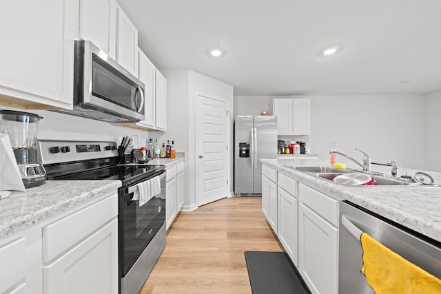 kitchen featuring sink, light hardwood / wood-style flooring, white cabinetry, and stainless steel appliances