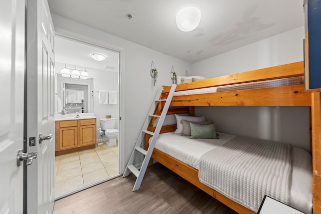 bedroom featuring sink, light hardwood / wood-style floors, and connected bathroom