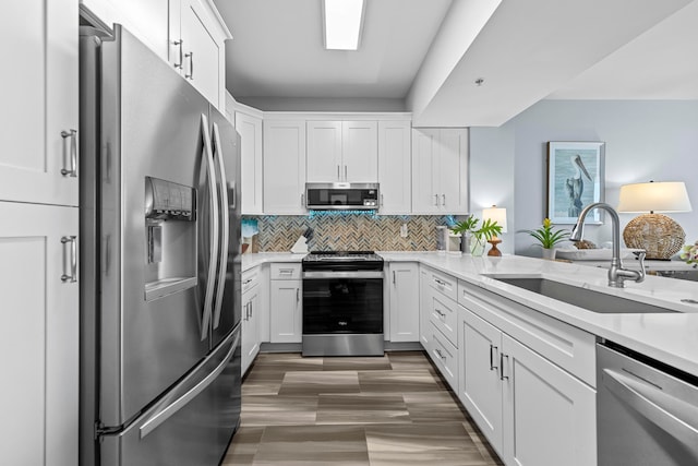 kitchen featuring white cabinets, sink, tasteful backsplash, stainless steel appliances, and light stone countertops