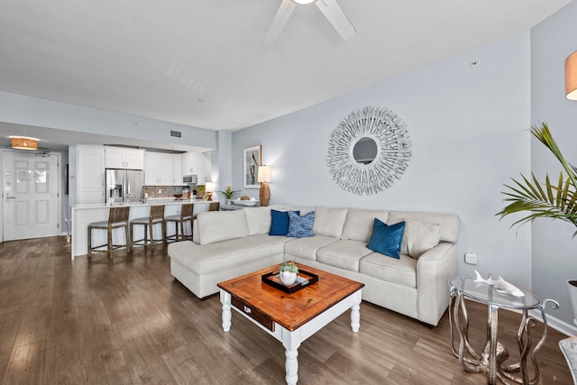 living room featuring ceiling fan and dark hardwood / wood-style floors