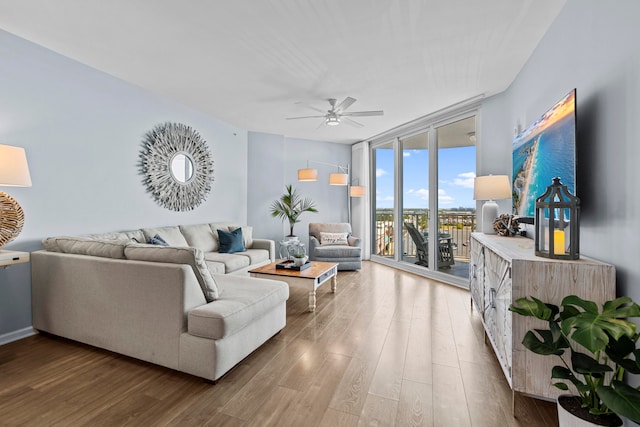 living room featuring hardwood / wood-style flooring, ceiling fan, and expansive windows