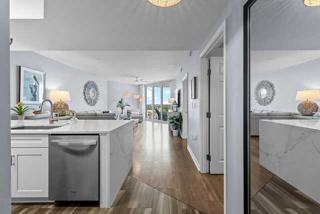 kitchen with white cabinets, sink, dishwasher, hardwood / wood-style floors, and light stone countertops