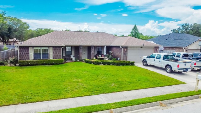ranch-style house featuring a garage, a front yard, driveway, and brick siding