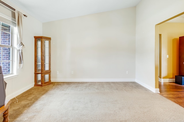 unfurnished room featuring baseboards, carpet flooring, and a wealth of natural light