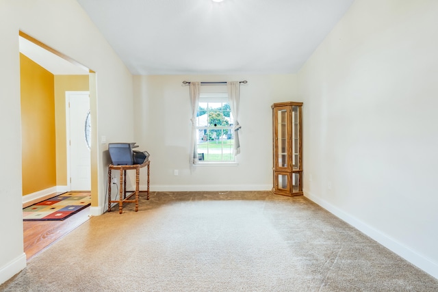 carpeted spare room featuring baseboards