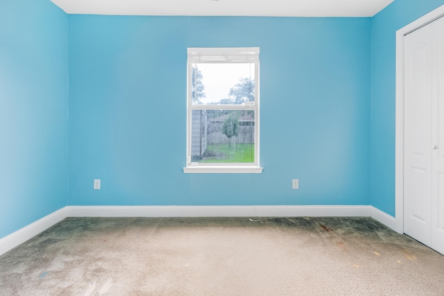 carpeted empty room with baseboards
