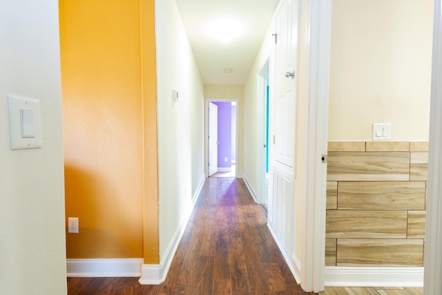hallway with baseboards and wood finished floors
