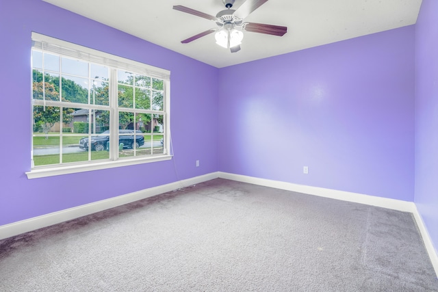 carpeted empty room featuring baseboards and a ceiling fan