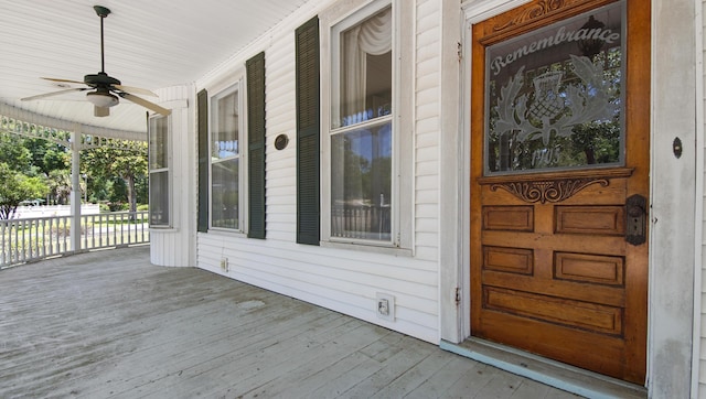 view of exterior entry featuring ceiling fan and a porch