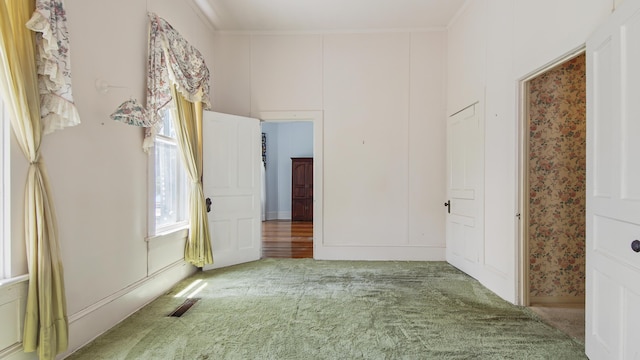 interior space featuring ornamental molding and carpet