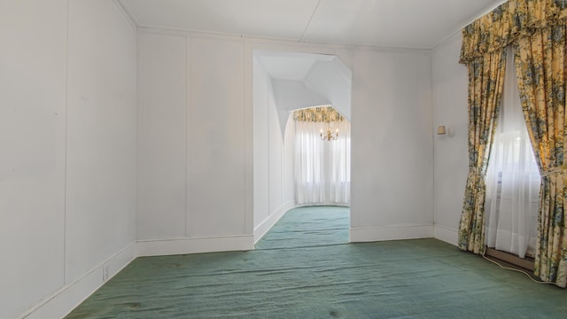 carpeted empty room featuring ornamental molding and a notable chandelier